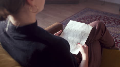 woman reading a letter at home