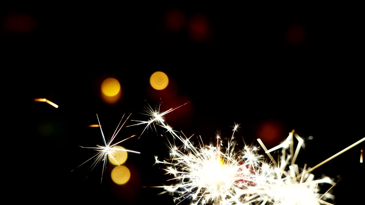 4k. Fuochi d'artificio e luci sfocate e intermittenti di ghirlande su sfondo scuro.