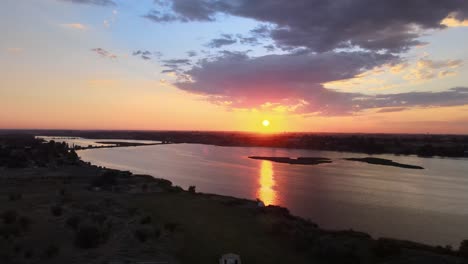 golden sunrise reflection broken up by silhouetted island, moses lake, washington, aerial