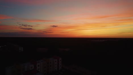 aerial view of the mexican sunset with dark resort buildings lying underneath