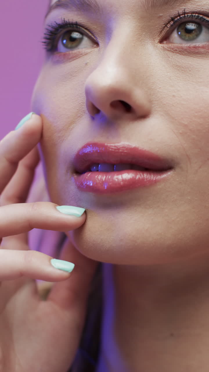 Vertical video of caucasian woman with make up touching face, copy space, slow motion