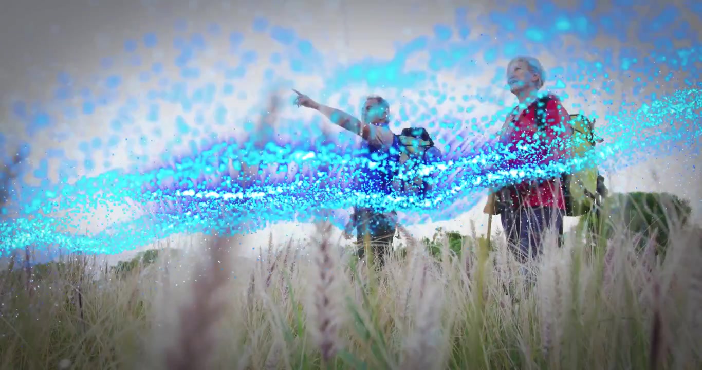 Two hikers in grass pointing and sparking blue particle wave passing under them showing technology