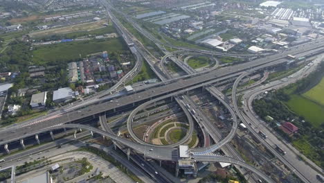 aerial view of highway road interchange with busy urban traffic speeding on road