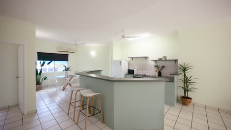 small modern tiled apartment kitchen curved bar area with tropical plants