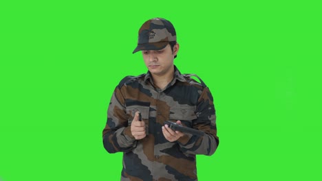 hombre del ejército indio inspeccionando su arma pantalla verde