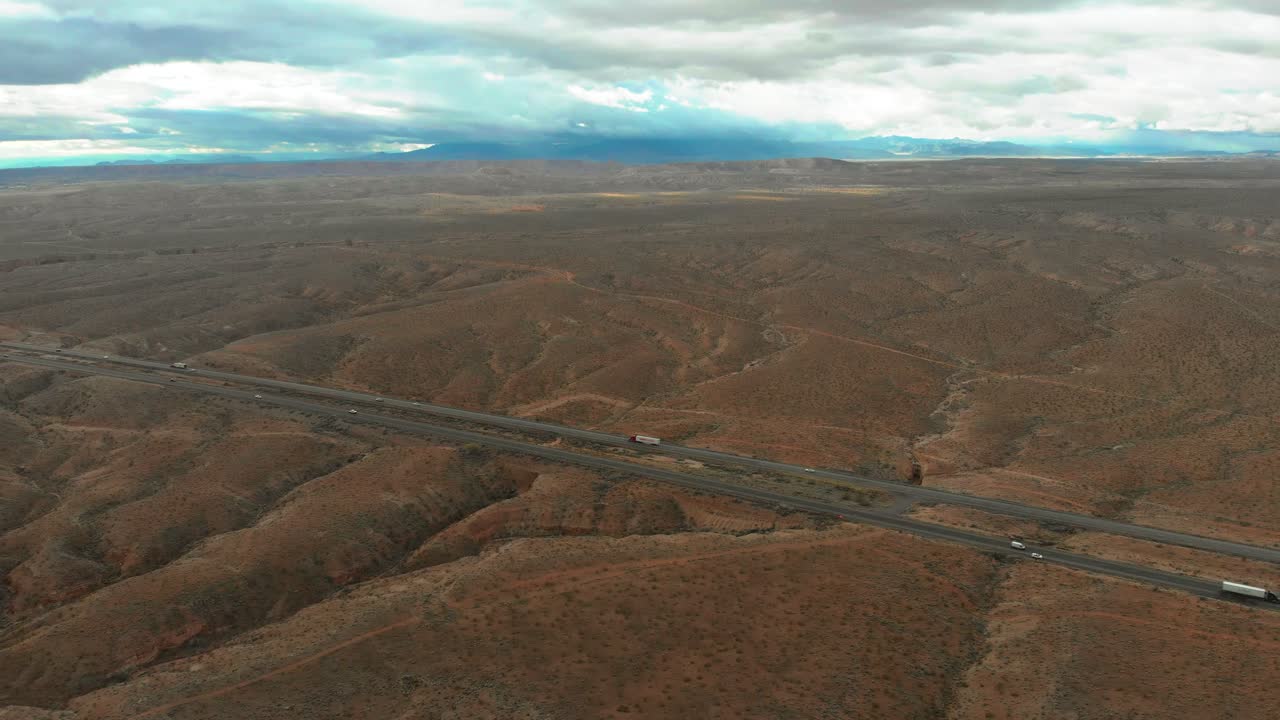 Aerial shot over the California deserts with a long stretch of well travelled highway.