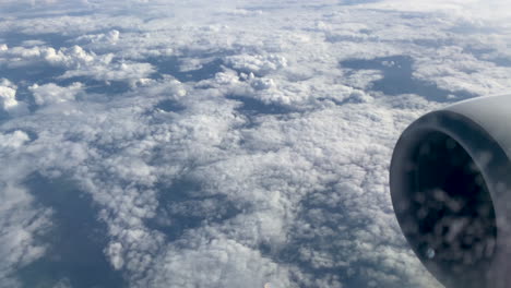 an amazing view of white clouds extending to the horizon shot through the window of an airplane, airplane turbine