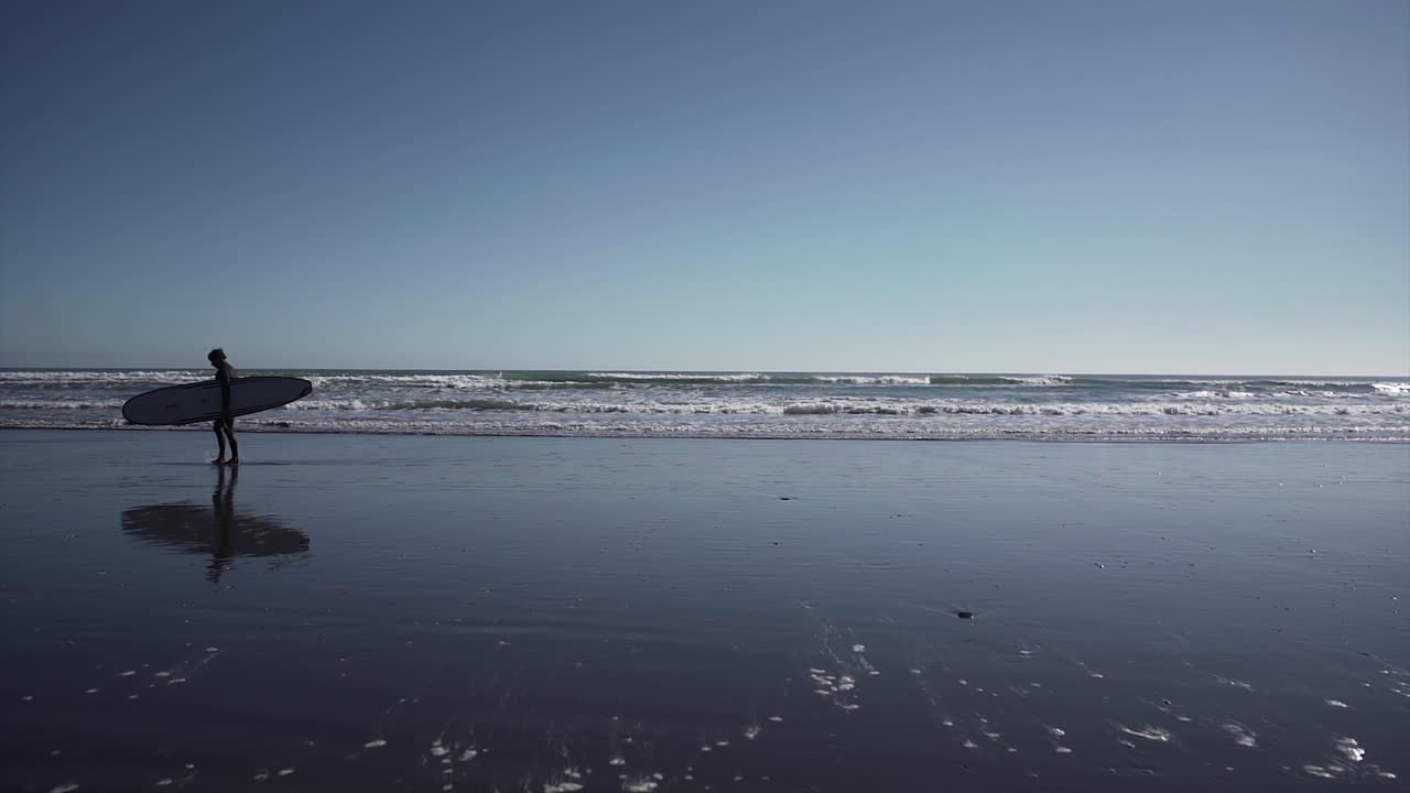 Person with Surfboard on a Beach