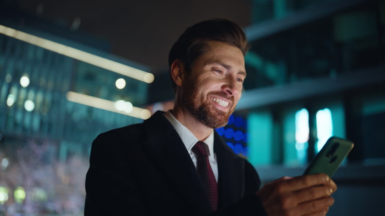 Evening businessman messaging smartphone at city darkness closeup. Man answering