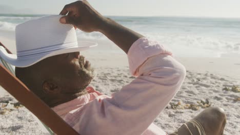 Senior-african-american-man-lying-on-sunbed-on-sunny-beach
