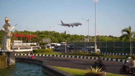 sunny day bali island airport district traffic street circle aircraft landing slow motion panorama 4k indonesia