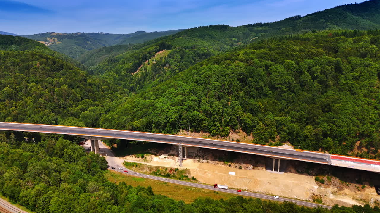New bridge crosses green valley. A new highway bridge spans a green valley, blending modern infrastructure with rolling hills of nature