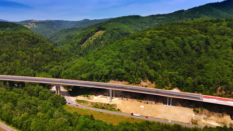 new bridge crosses green valley. a new highway bridge spans a green valley, blending modern infrastructure with rolling hills of nature