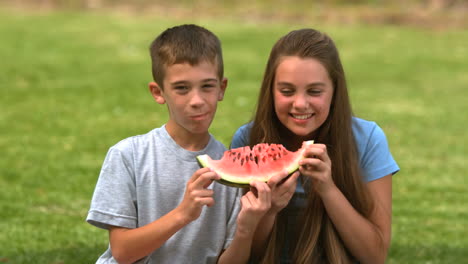 siblings eating watermelon together