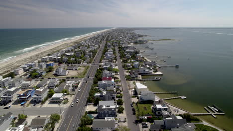 Skinny-Island-Beach-Town-with-both-bayside-and-ocean-visible,-Aerial-shot,-revealing-water-tower