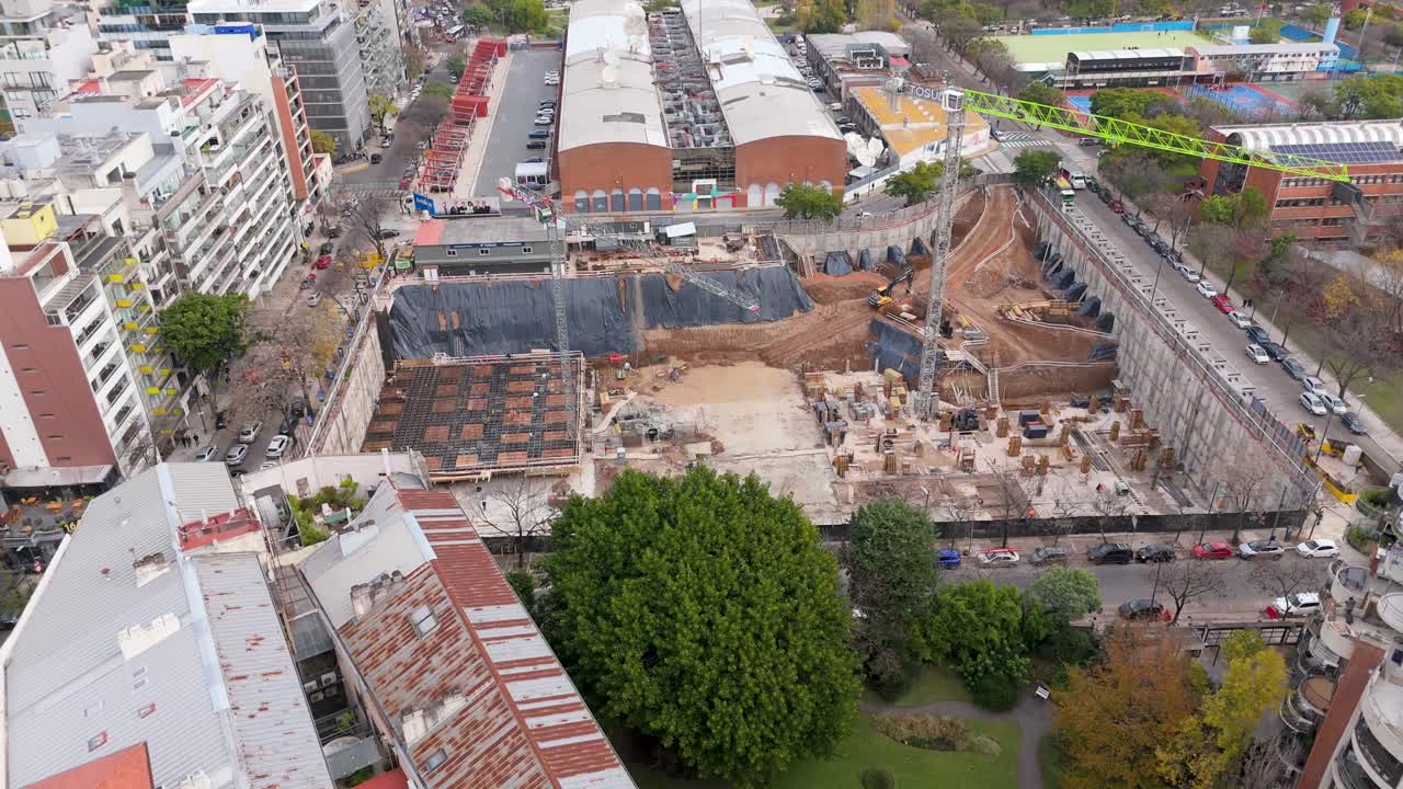 A construction site in buenos aires with surrounding buildings and a crane, aerial view