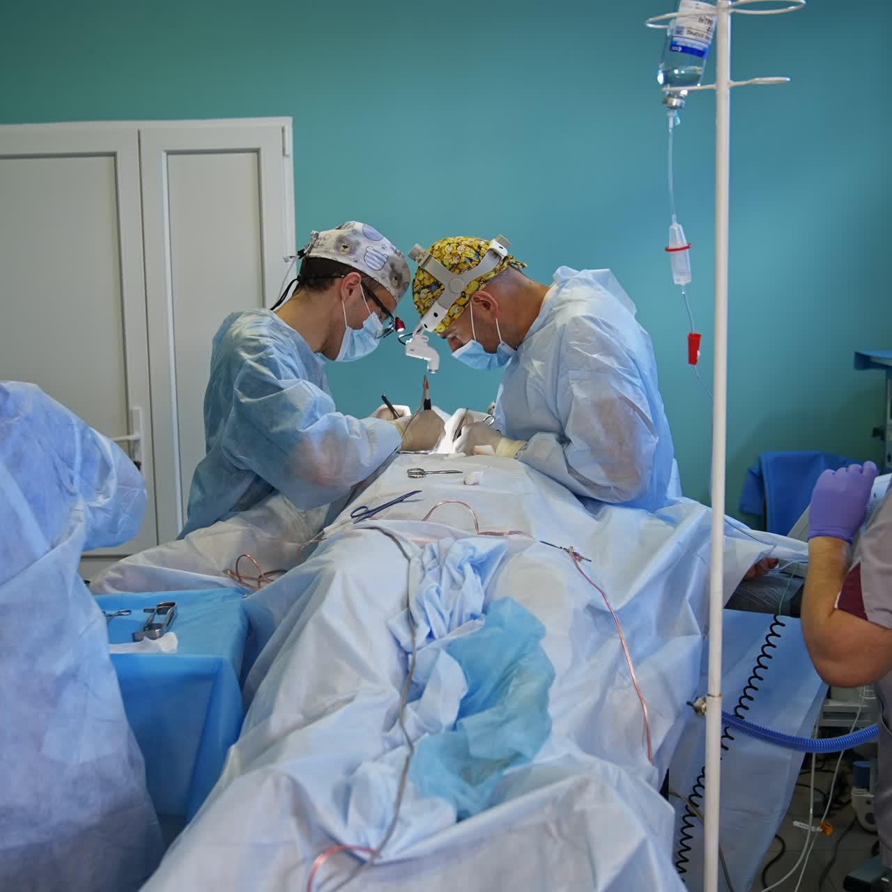 Medical team working in the ordinary surgical room. Surgeons operate thyroid and nurse is setting the drop counter