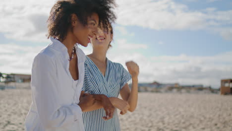 Zwei-Mädchen-Gehen-An-Einem-Sonnigen-Tag-Am-Strand-Spazieren,-Nahaufnahme.-Fröhliches-Homosexuelles-Paar-Im-Gespräch