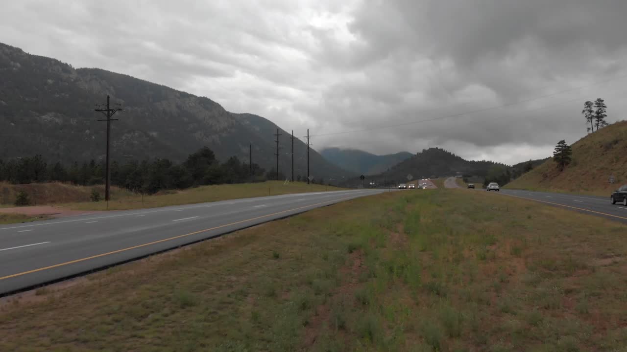 Meridian aerial of traffic on divided mountain highway in heavy cloud