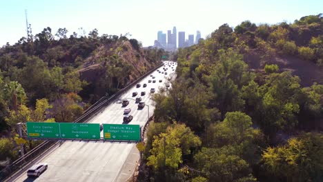 aerial freeway cars travel along the 110 freeway in los angeles through tunnels and towards downtown skyline 3