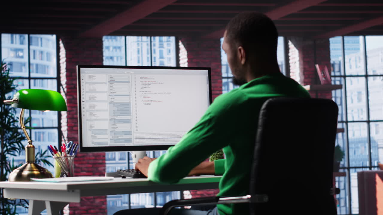 Black IT developer at PC coding and creating an app software