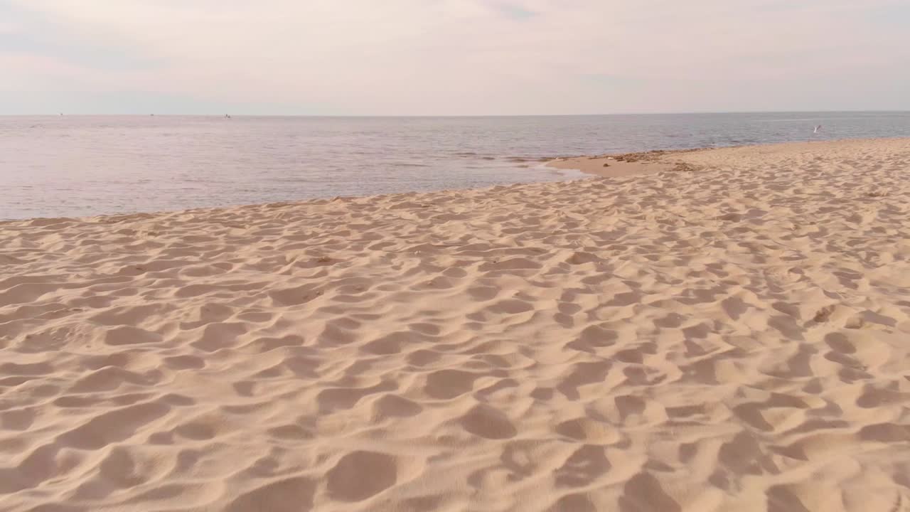 낮은 조감도의 하얀 모래 해변, 바다 위의 파스텔톤 일몰