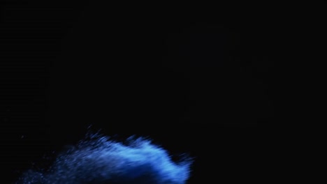 Video-of-blue-sand-grains-thrown-in-air-and-copy-space-on-black-background