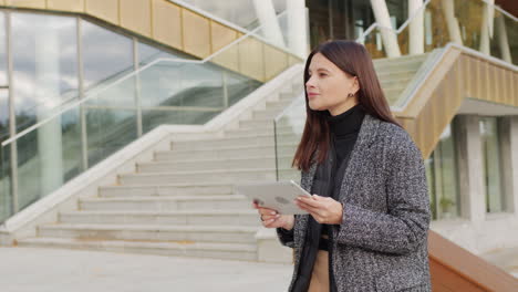 woman using a tablet and riding a segway in a modern urban environment