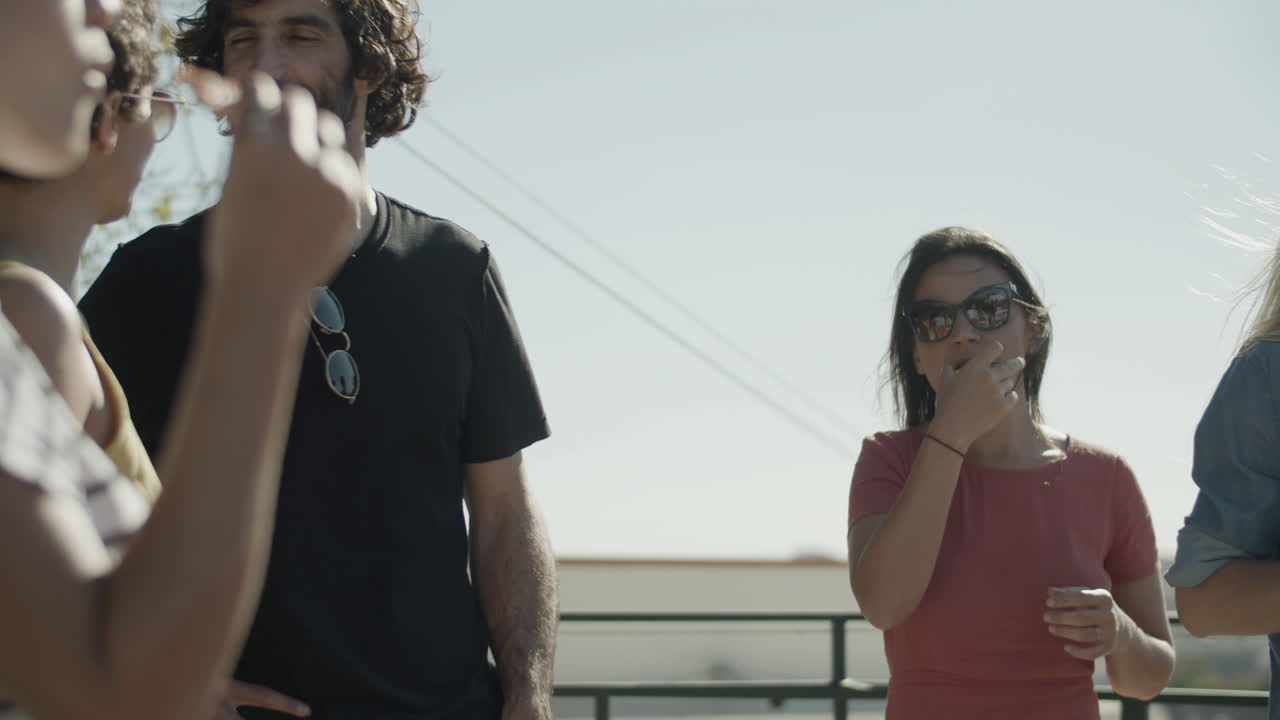 맥주를 마시고 옥상 파티에서 피자를 먹으면서 함께 이야기하는 웃는 친구들