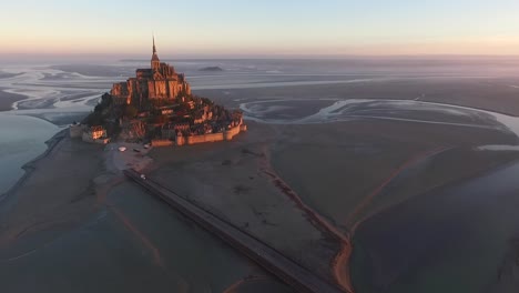 Mont-Saint-Michel-Und-Die-Bucht-Bei-Sonnenuntergang-Mit-Brücke,-Die-Die-Küste-Der-Insel-Verbindet,-Normandie-In-Frankreich