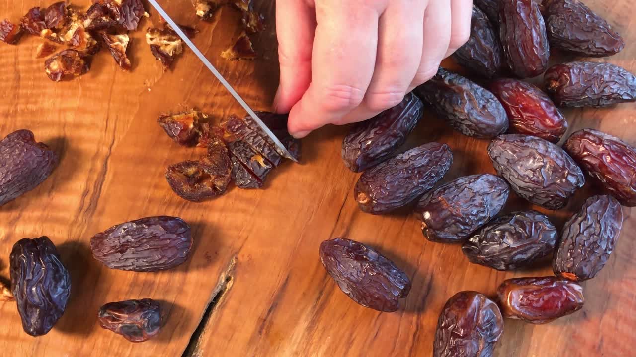 chopping dried Medjool dates on cutting board flat lay
