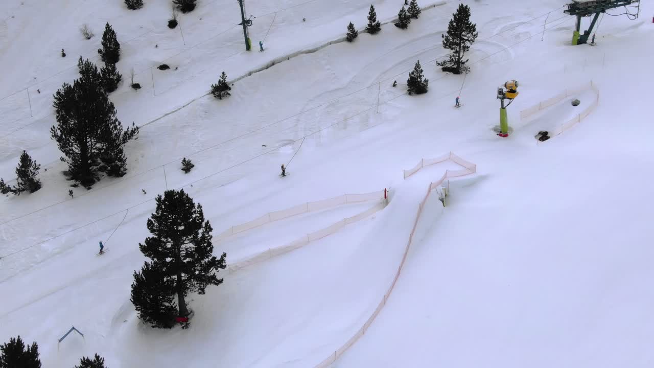 Aerial view of ski slope with snow cannon and skiers, snow tunnel visible, Ordino Arcalis, Andorra