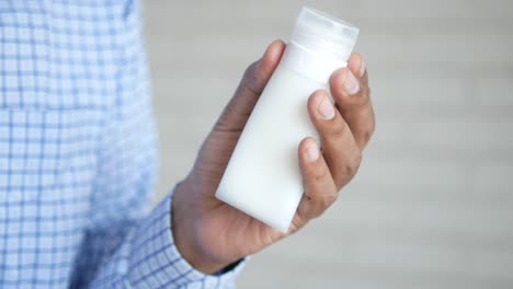 hand holding a white cosmetic bottle