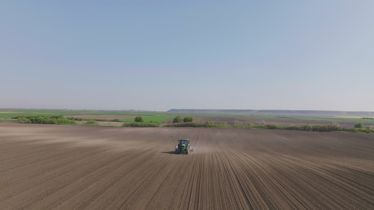 Agricultural Tractor Planting Crops in Field