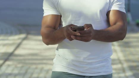 Ausgeschnittene-Aufnahme-Eines-Afroamerikaners-Mit-Smartphone-Im-Freien.