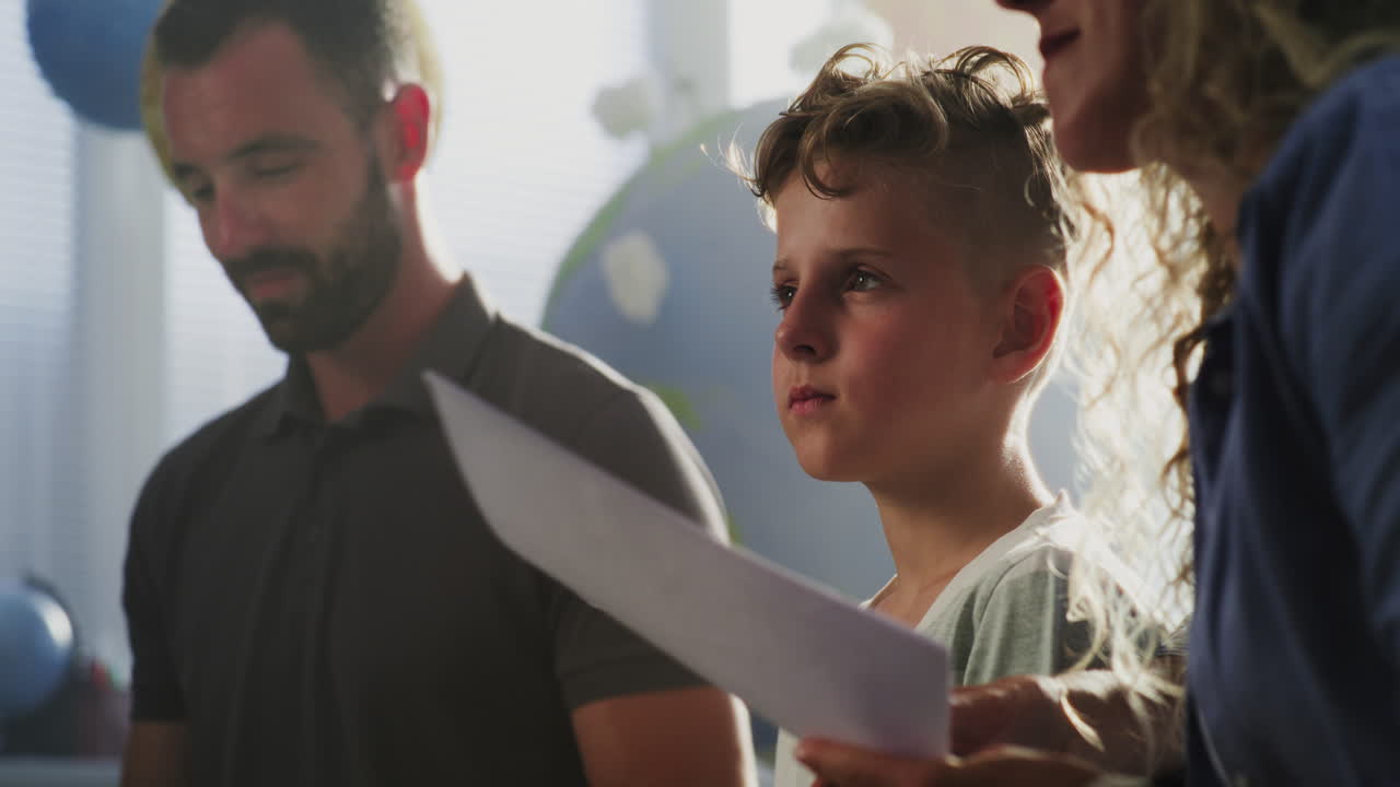 Mother and Father Looking at School Test Grades of Their Son During Parents Evening