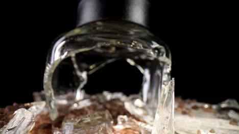 Pulling-away-from-a-broken-sea-salt-grinder,-starting-with-the-top-portion-standing-upright-filling-the-frame,-wide-angle-macro-view-of-the-broken-glass-and-a-larger-portion-of-salt-at-the-end