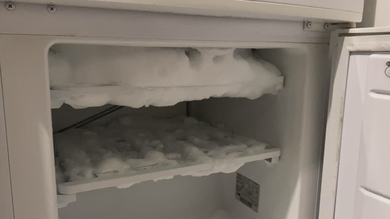 Old you freezer covered with ice, white fridge filled with frost and icing