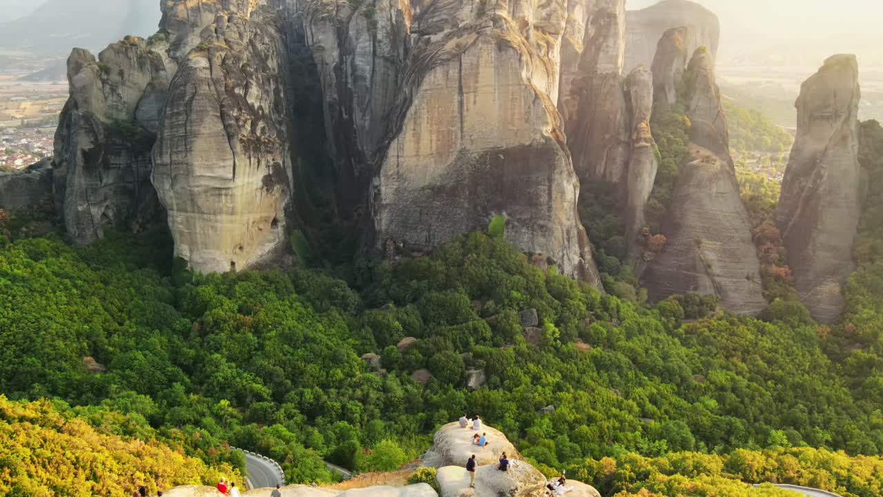 Aerial drone view of the Meteora in Greece at sunset. Rock formations with viewpoint full of people. A lot of greenery, sacred place