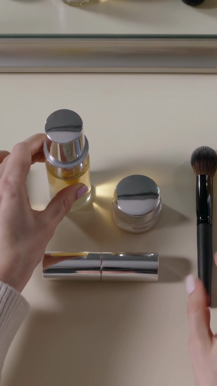 Vertical video: Entering hands in cream sleeves arranging pump, jar, tube, brush on vanity tidying