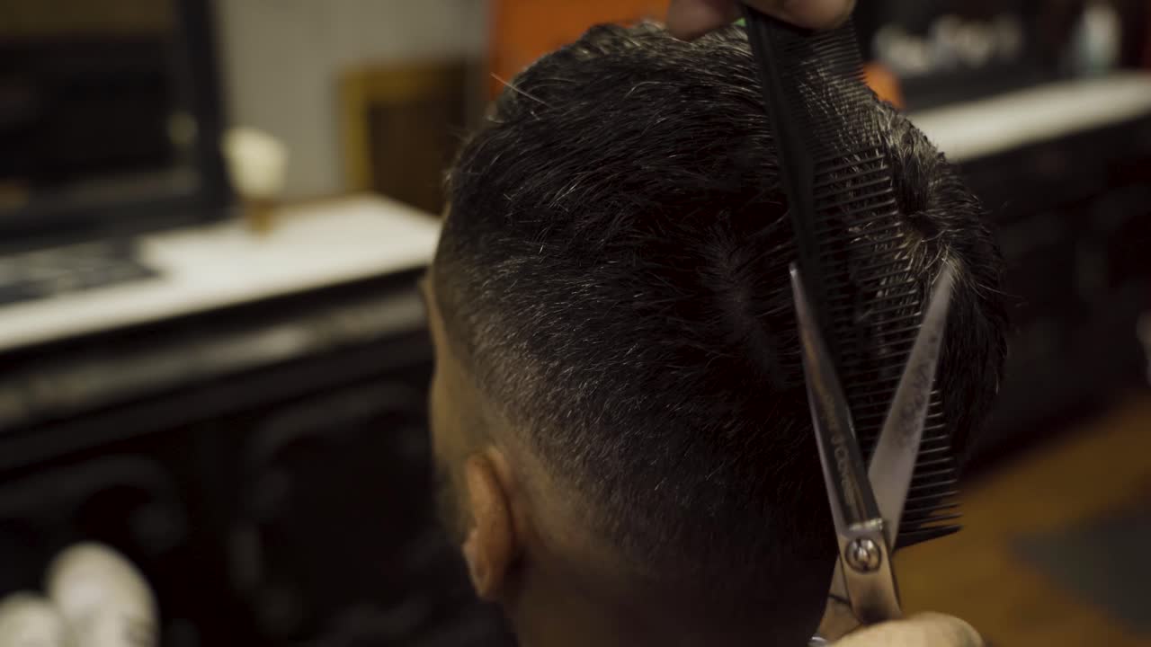 vista de primer plano de un hombre haciendo un corte de pelo elegante en un salón