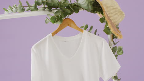 video de un primer plano de una camiseta blanca colgando sobre un fondo púrpura