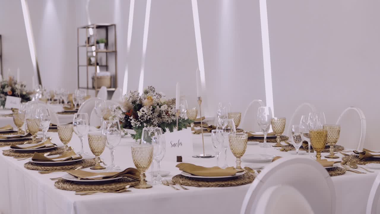 Luxurious wedding reception table with floral centerpieces, gold accents, and glassware