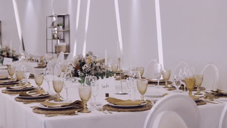 luxurious wedding reception table with floral centerpieces, gold accents, and glassware