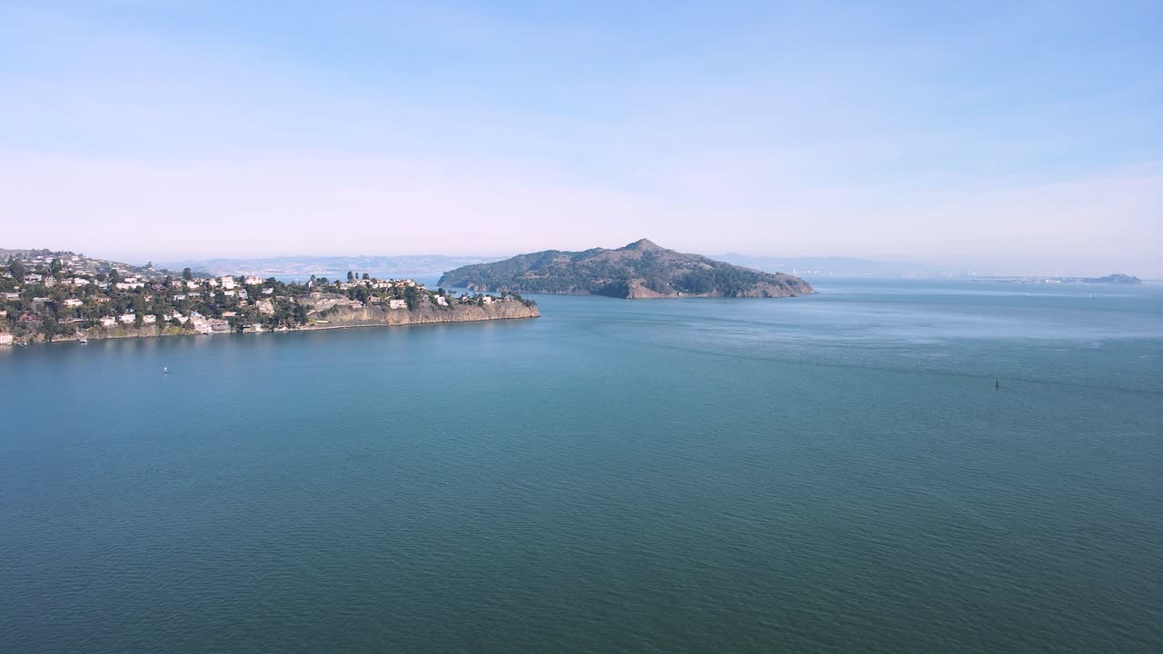 Aerial video capturing Angel Island's natural beauty, Sausalito's coastal charm, and the distant urban silhouette of San Francisco