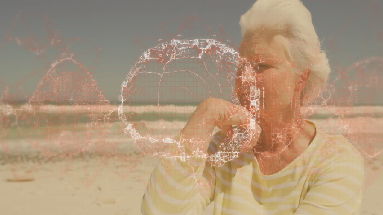 Elderly woman at beach with digital network animation overlaying her