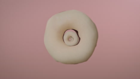 white glaze donuts on a light pink background