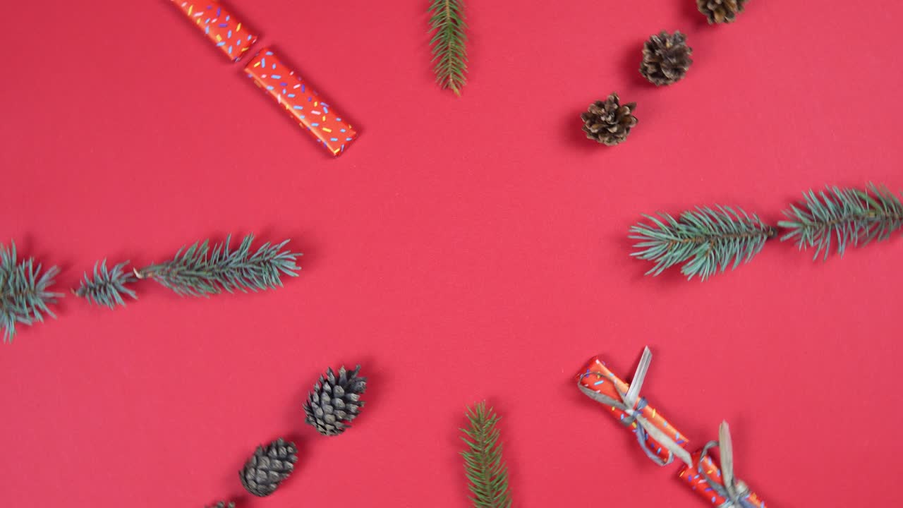 patrón abstracto de navidad rotación de 360 grados. ramas de abeto, caja de regalos y cono girando sobre fondo rojo.