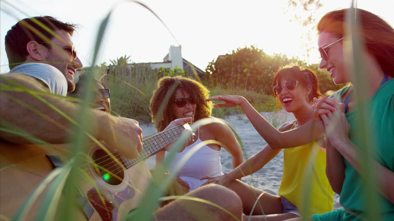 다민족 남녀가 해변 파티를 즐기고 있습니다.