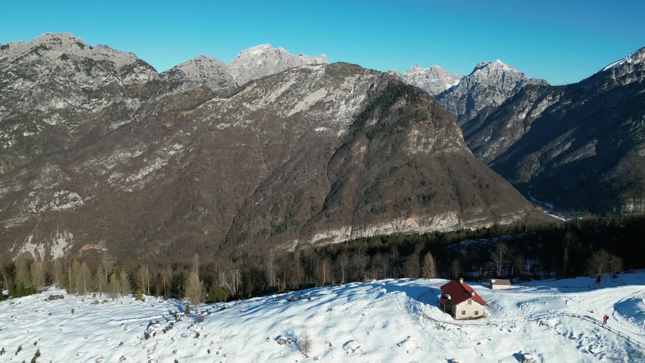 Filmato aereo realizzato con drone sopra il Rifugio Pradut, Italia: giornata di dicembre limpida con montagne soleggiate senza neve e pendii ombreggiati coperti di neve. Perfetto per progetti invernali, alpini e naturalistici